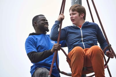 Staff assisting a resident on a swing