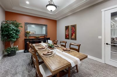 Elegant dining room with a wooden table and decorations.