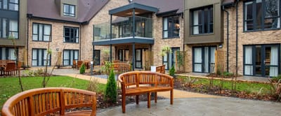 Outdoor seating area with benches and landscaping.