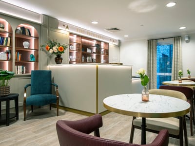 Cozy common area with seating and decorative shelves.