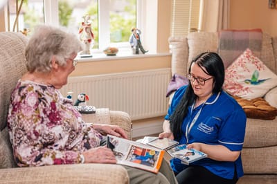 Caregiver engaging with a resident in a cozy setting.