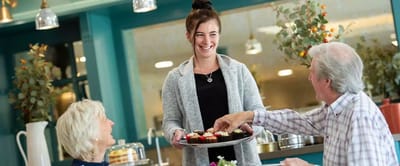 Staff serving desserts to happy residents