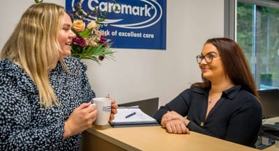 Reception area with staff interacting at Caremark.
