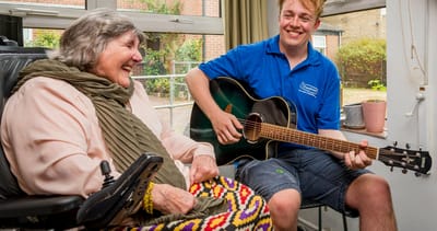 Resident enjoying music therapy with staff member.