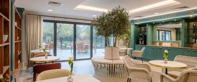 Bright common area with tables and greenery