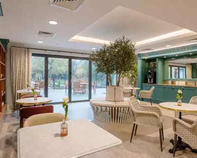 Common area with tables, chairs, and a view of the outdoor space.