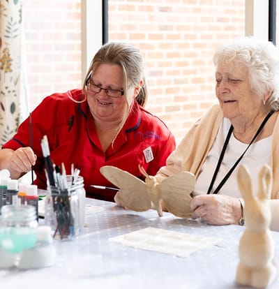 Staff member and resident engaged in art activity.