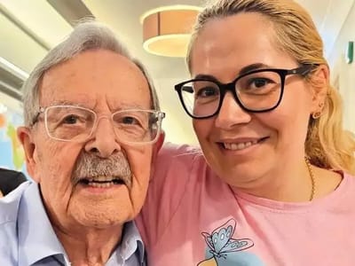 Senior resident with caregiver smiling together.