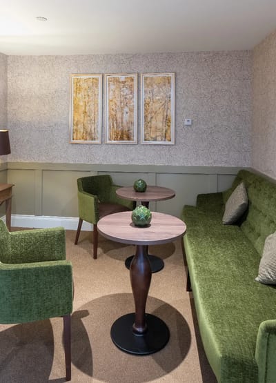 Cozy common area with green seating and artwork.