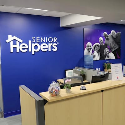 Reception area with logo and smiling residents' photo.