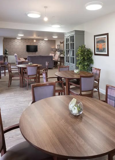 Common area with tables and chairs in well-lit interior
