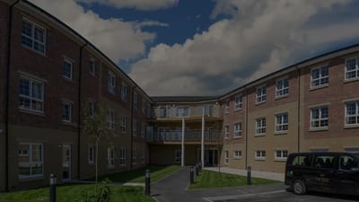Exterior view of Escan Manor with green space.