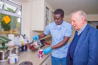 Caregiver serving tea to a senior resident.