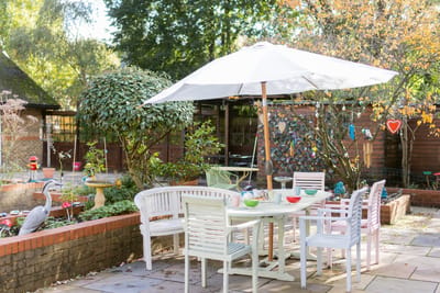 Outdoor dining area with seating and garden features.