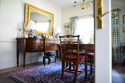 A well-furnished interior room with a dining table and decorative mirror