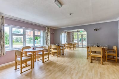 Bright dining area with wooden chairs and tables.