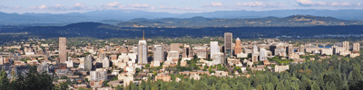 Aerial view of a city skyline and mountains.