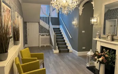 Welcoming entryway with chandelier and seating area