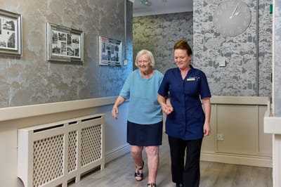 Staff assisting a resident in the hallway