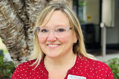 Smiling staff member with a name tag outdoors