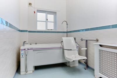 Accessible bathing area with grab bars and shower seat.