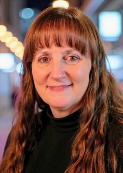 Smiling female staff member in a casual setting.