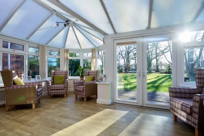 Bright conservatory with armchairs and garden view
