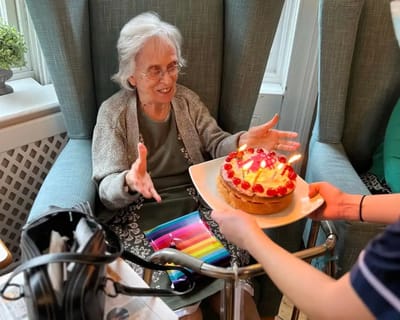 Resident enjoying a birthday cake celebration.
