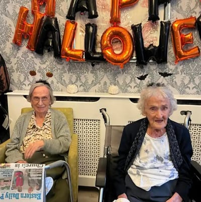 Two residents celebrating Halloween indoors.