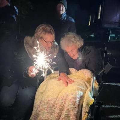 Two women celebrating with sparklers outdoors.