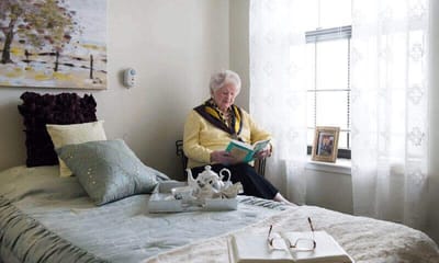A resident reading in her private room