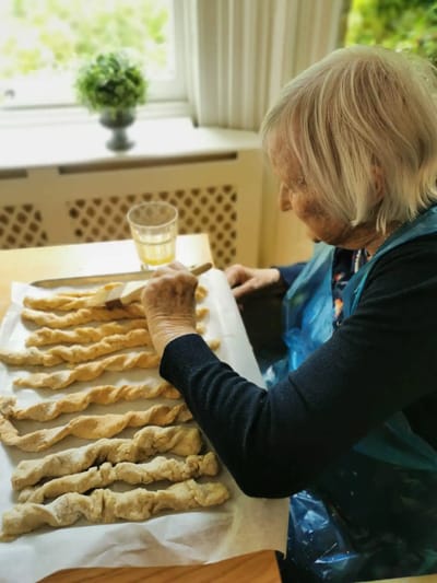 Senior resident baking in a cozy kitchen setting.