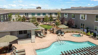 Outdoor pool area with seating and landscaped gardens