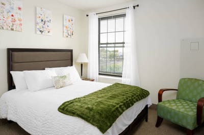 Cozy resident room with bed and armchair