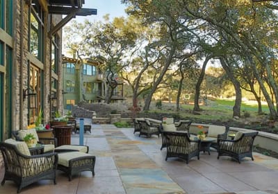 Outdoor patio area with seating and greenery.
