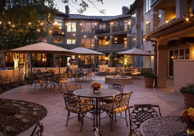 Outdoor courtyard with tables and string lights.
