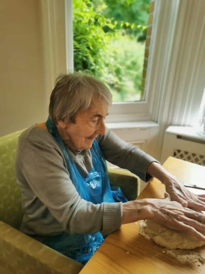Senior resident engaging in baking activity.