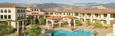 Outdoor pool area with mountains in background.