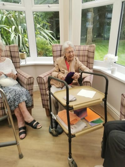 Residents enjoying a sunny indoor common area.