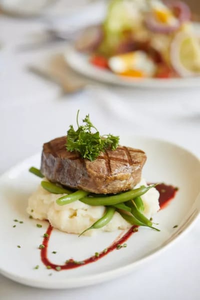 Plate of steak with green beans and mashed potatoes