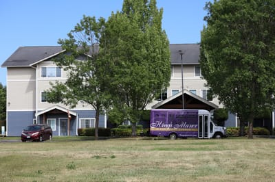 Exterior view of King's Manor with a facility vehicle