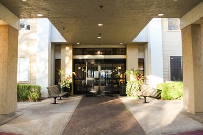 Exterior entrance of The Windham by Cogir with benches