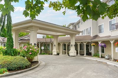 Entrance of a senior living facility with outdoor flowers