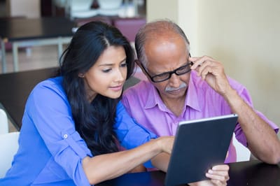 Staff assisting a senior resident with a tablet
