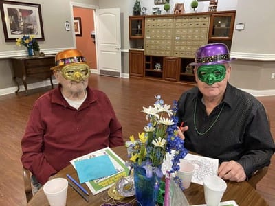 Two residents in festive masks at a celebration