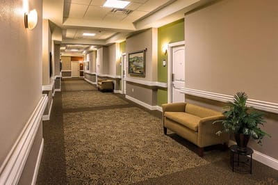 A well-lit hallway with seating area and decor