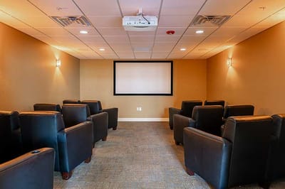 A cozy, well-lit theater room with seating