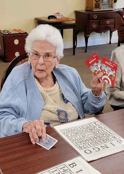 Resident playing bingo with cards in a common area