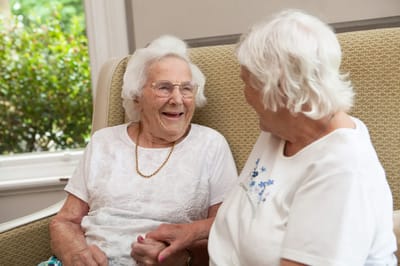 Two residents enjoying a conversation in a cozy common area