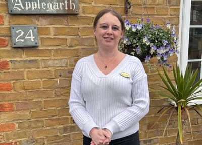 Staff member in front of Applegarth Care Home